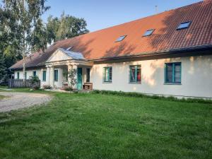 a white house with an orange roof and a yard at Dom Jogi Studzieniec in Studzieniec