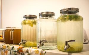 three glass jars filled with liquid on top of a counter at Dom Jogi Studzieniec in Studzieniec +43 photos