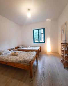 a room with two beds and a window at Dom Jogi Studzieniec in Studzieniec