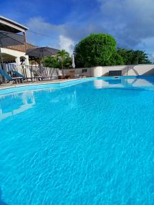 a large swimming pool with blue water at Ti Village Creole in Sainte-Anne