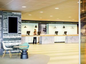 a lobby with a desk with laptops on it at Ibis Schiphol Amsterdam Airport in Badhoevedorp
