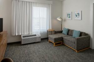 a living room with a couch and a window at TownePlace Suites by Marriott Foley at OWA in Foley