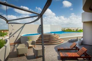 a patio with chairs and a swimming pool at Phimai, Tu Lugar Magico En Tulum in Tulum