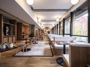 a restaurant with tables and chairs and windows at Mercure Grenoble Centre Alpotel in Grenoble