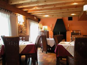 uma sala de jantar com duas mesas e cadeiras com toalha de mesa vermelha em C.T.R. Camino de la Fuentona em Cabrejas del Pinar
