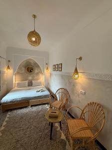 a bedroom with a bed and a table and chairs at Riad Yu Yu in Marrakech