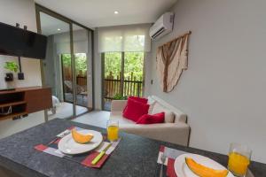 a living room with a table with plates of fruit on it at Phimai, Tu Lugar Magico En Tulum in Tulum