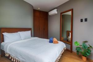 a bedroom with a large white bed with a mirror at Phimai, Tu Lugar Magico En Tulum in Tulum +13 photos