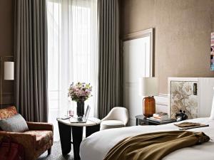 a hotel room with a bed and a chair and a window at Sofitel Le Scribe Paris Opera in Paris