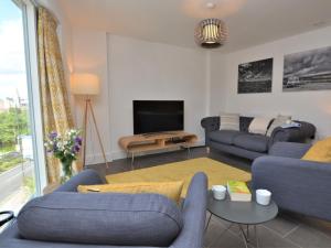 a living room with blue couches and a tv at 2 Bed in Bournemouth 48516 in Bournemouth