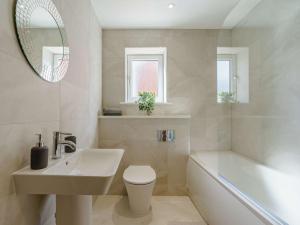 a bathroom with a sink and a toilet and a tub at 4 Bed in Whitley Bay 87396 in Whitley Bay +18 photos