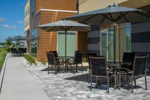 a patio with tables and chairs with umbrellas at Fairfield Inn & Suites by Marriott Foley in Foley