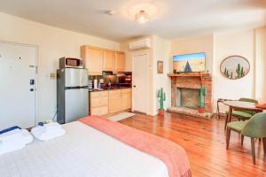 a room with a bed and a kitchen with a fireplace at 99 Walk Score half Block to King Western Studio in Alexandria +40 photos