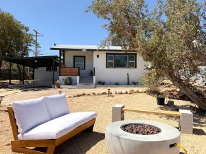 a couch and a fire pit in front of a house at Joshua Tree - Under the Stars-Pool, Spa & Fire pit in Yucca Valley