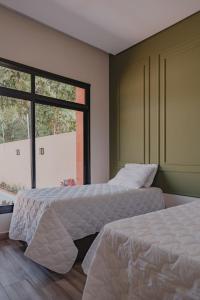 Dos camas en una habitación con ventana. en Casa D'Mata Experience unforgettable moments in FOZ, en Foz do Iguaçu 24 fotos más