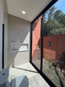 baño con aseo y puerta de cristal en Casa D'Mata Experience unforgettable moments in FOZ, en Foz do Iguaçu