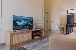 Una sala de estar con un televisor de pantalla plana en un centro de entretenimiento. en Casa D'Mata Experience unforgettable moments in FOZ, en Foz do Iguaçu