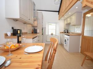 a kitchen with a wooden table with a bowl of fruit at 1 Bed in Porthgain 61170 in Porthgain