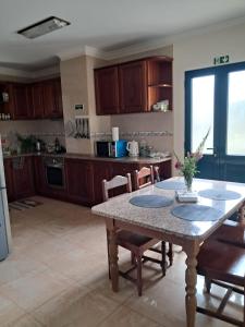 a kitchen with a table and chairs and a table and a kitchen at Casa Costa in Santa Maria Madalena +22 photos