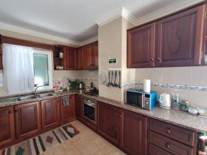 a kitchen with wooden cabinets and a microwave at Casa Costa in Santa Maria Madalena