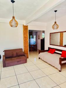 un salon avec un lit et un canapé dans l'établissement Residencial Adriê, à Itacaré