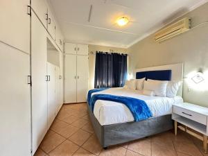 a bedroom with a bed with a blue and white comforter at 3 Bedroom House in Nelspruit in Nelspruit