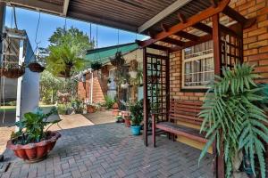 a patio with a wooden bench and plants at 3 Bedroom House in Nelspruit in Nelspruit