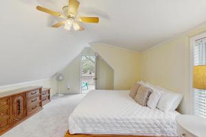 a bedroom with a bed and a ceiling fan at The Treehouse at 10th in Folly Beach