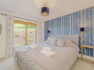 a bedroom with a large white bed with blue wallpaper at 2 Bed in Montgomery 83244 in Llandyssil