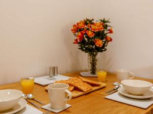 a table with a vase of flowers and a table with food at 1 Bed in South Molton 89089 in South Molton +6 photos