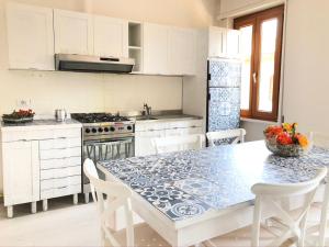 a kitchen with a table with a blue and white table cloth at Olympic Clua' House in Porto Ceresio