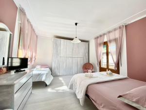 a bedroom with two beds and a flat screen tv at Olympic Clua' House in Porto Ceresio