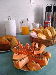 a table topped with two plates of bread and fruit at Pousada Divino Espírito Santo in Paraisópolis
