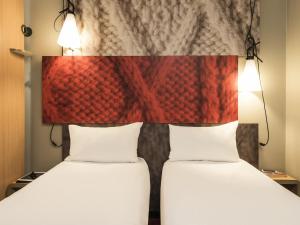 two beds in a room with a headboard at ibis Compiegne in Compiègne +57 photos