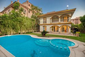 a house with a swimming pool in front of a house at Host Prime Villas in Cairo