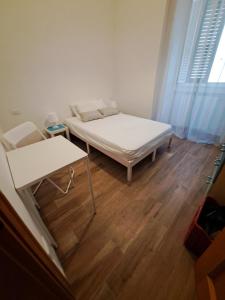 a bedroom with a bed and a table and a window at B&B Vola Vola Vola in Ortona