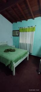 ein Schlafzimmer mit einem grünen Bett und einem Fenster in der Unterkunft Humli in Resistencia
