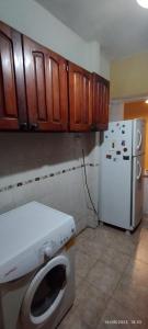 eine Küche mit einer Waschmaschine und einem Kühlschrank in der Unterkunft Humli in Resistencia + 7 Fotos