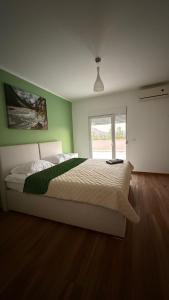 a bedroom with a large bed with a green wall at Villa Nadia in Bar