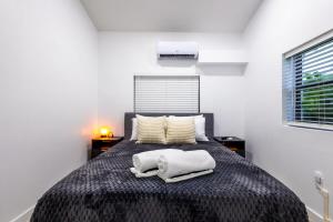 a bedroom with a bed with two towels on it at The Side Villa in Miami
