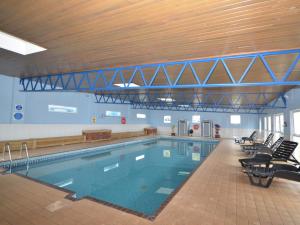 a large swimming pool in a building with chairs at 2 Bed in Brixham BX054 in Brixham