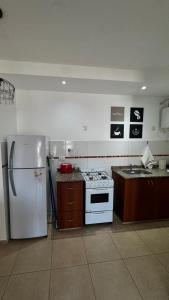 a kitchen with a white stove and a refrigerator at Catamarca Apart in Villa María +7 photos