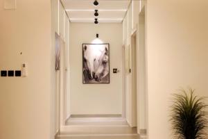 アル・ウラーにあるAlSULTANA APARTMENTSの壁に犬の絵が飾られた廊下 +1枚の写真
