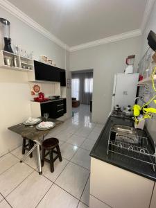 a kitchen with a sink and a counter top at Flat Centro 301 in Tangara da Serra +3 photos