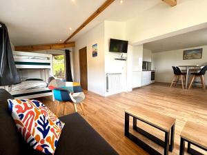 a living room with a couch and a bed and a table at Le chalet de neptune in Socoa