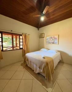 a bedroom with a bed and a ceiling fan at Recanto Búzios Arpoador Suítes in Búzios