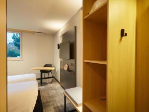 a small room with a bed and a table at ibis Le Mans Est Pontlieue in Le Mans
