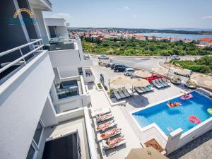 an apartment with a swimming pool and a balcony at Residences Bellavista 2 in Novalja