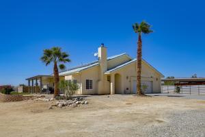 una casa con dos palmeras delante de ella en Desert Escape 360 Mtn Views, Pool, Spa and Fire Pit, en Dos Palmas Corners