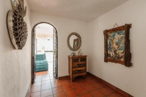 Un pasillo con un espejo y una silla azul. en Quinta Tere Country House, en Tesistán 101 fotos más